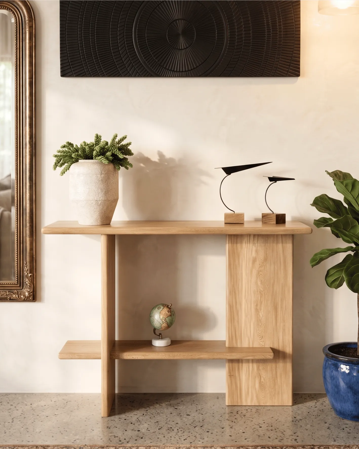 Light wood console with plant, bird sculptures and blue planter beside a mirror