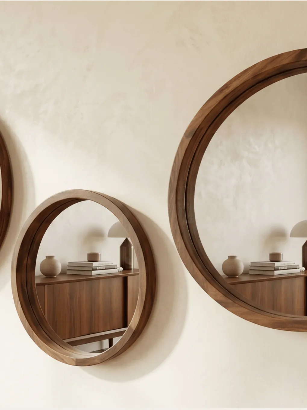 Round wooden mirrors on a plaster wall, reflecting a garden doorway
